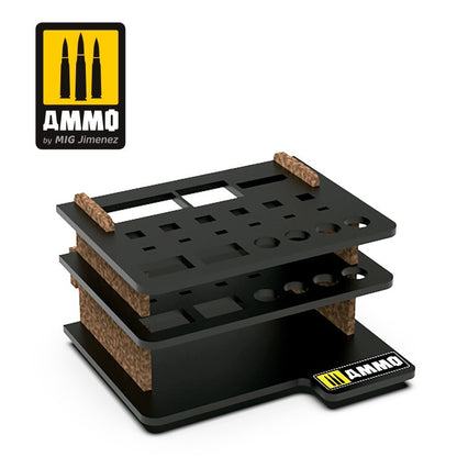 An empty, black, multi-tiered AMMO brand organizer with brown supports and varied cutouts for hobby tools and paints
