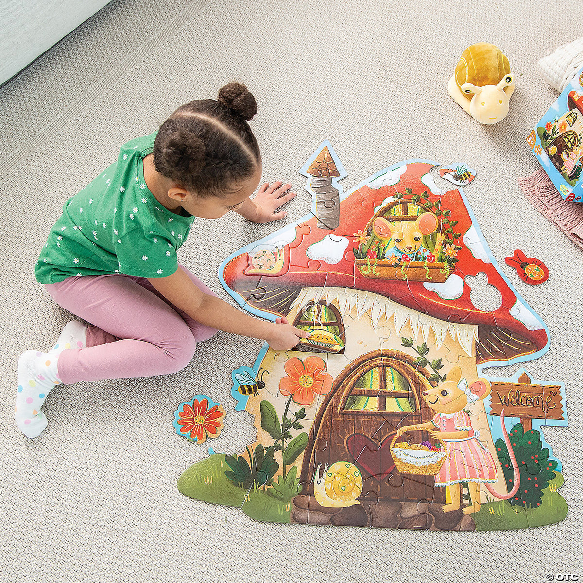 Child assembling the Mouse House puzzle on the floor