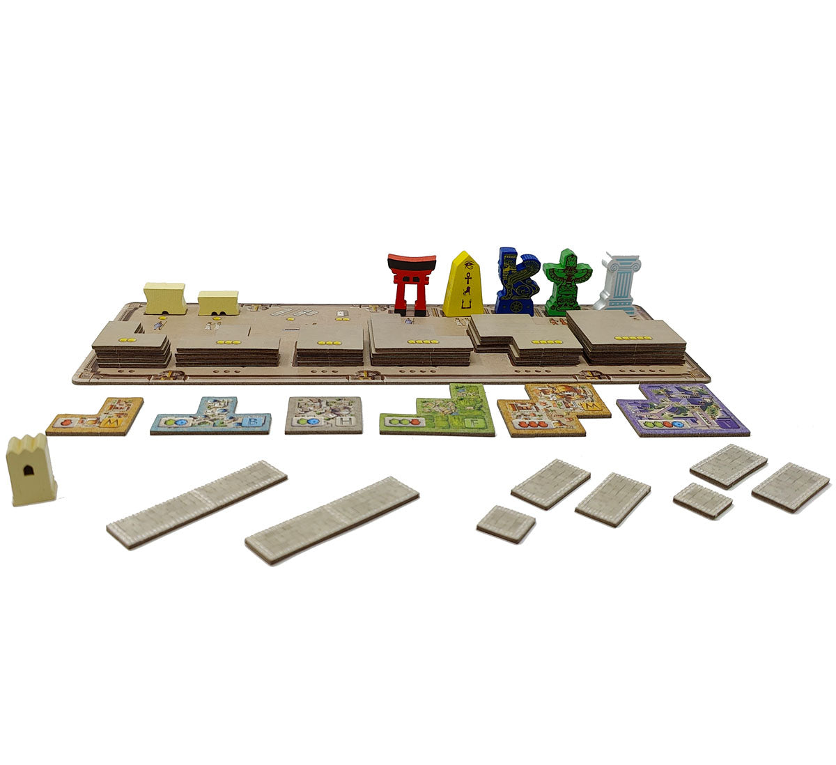 A board game setup featuring a brown modular board, colourful wooden monuments (torii, ankh, column), a castle, and various building tiles.