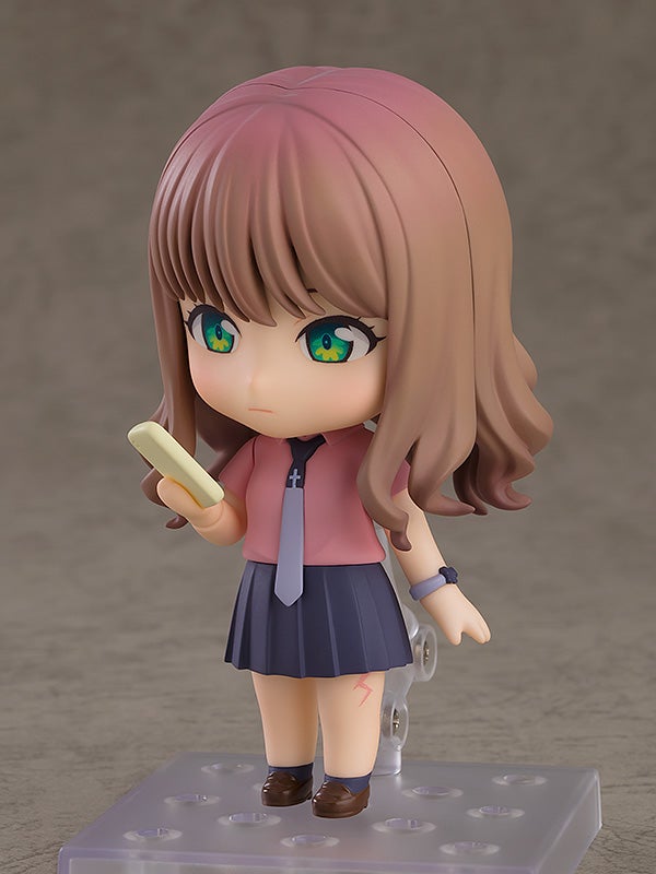 Nendoroid figure of a girl in a pink shirt gray tie and dark blue skirt holding a small mobile in her hand
