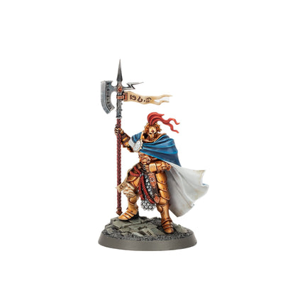 A golden armored warrior miniature with a blue cape holding a polearm with a banner standing on a rocky base