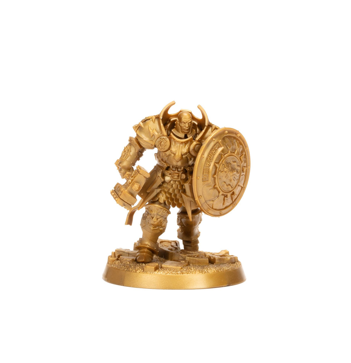 An ornate gold miniature of a bald armored warrior wielding a hammer and shield on a textured base