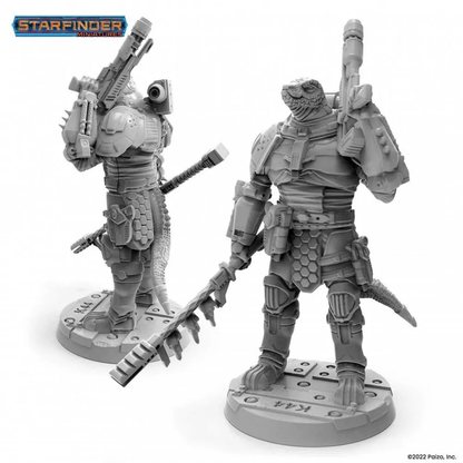 Two unpainted gray Starfinder Obozaya Vesk Soldier miniatures of armored reptilian aliens holding futuristic rifles, one with a staff