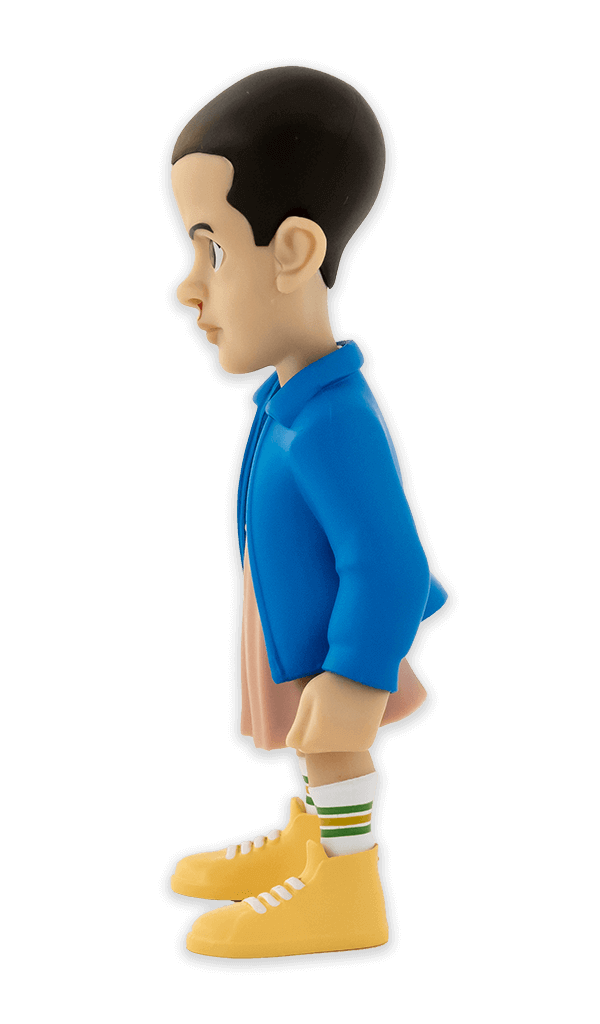 Side view of Minix Stranger Things Eleven collectible vinyl figure with blue jacket pink dress and nosebleed wearing striped socks and yellow shoes