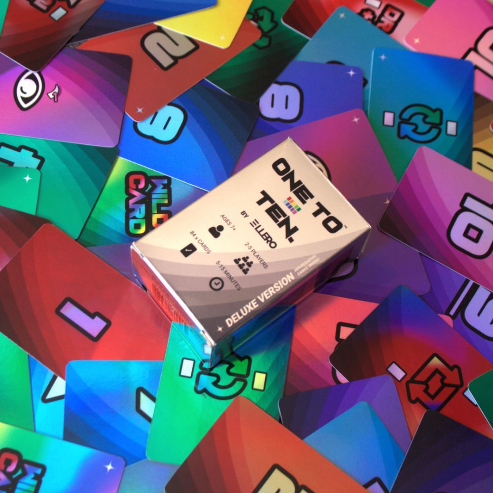 White &#39;One to Ten&#39; game box resting on a pile of colourful, iridescent game cards
