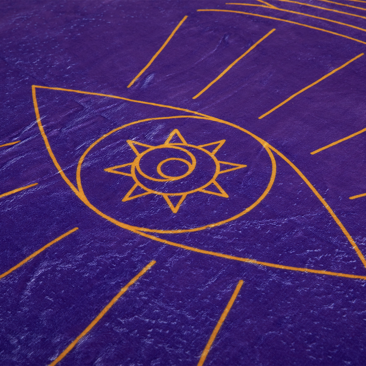 Purple Oracle of the Moon Tarot blanket with a yellow stylized eye, a sun-like center, and radiating lines