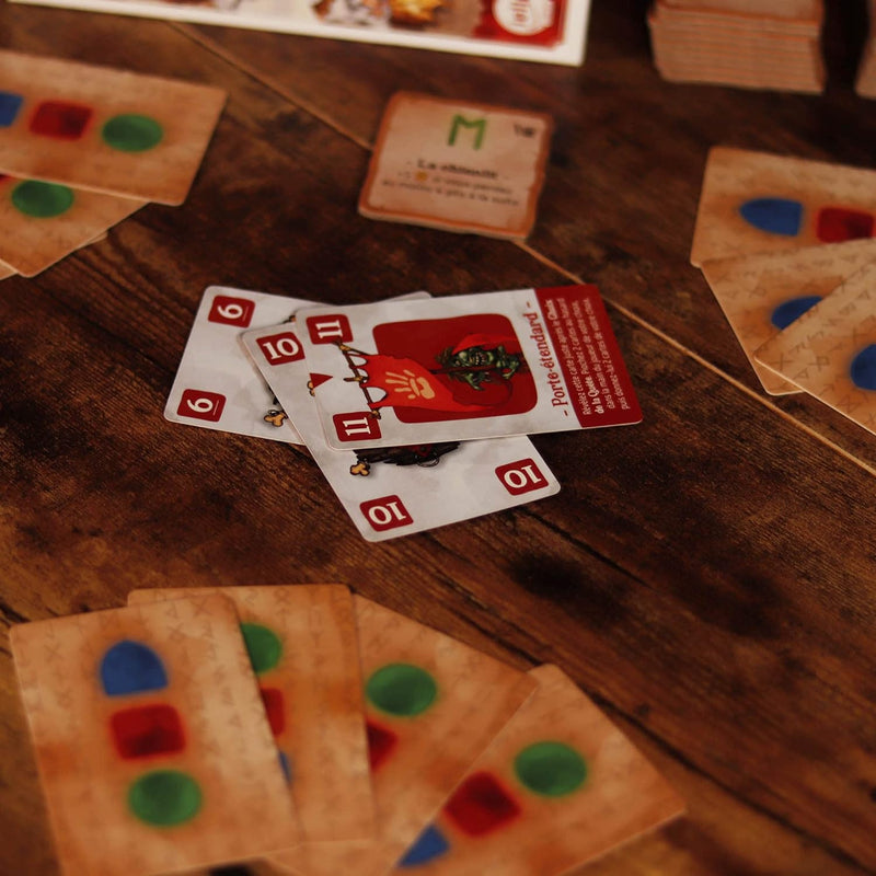 Various game cards from a board game laid out on a wooden table
