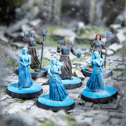 Six fantasy miniatures: three dark-robed figures (two with staffs, one holding a crystal), and three ethereal blue female spirits.
