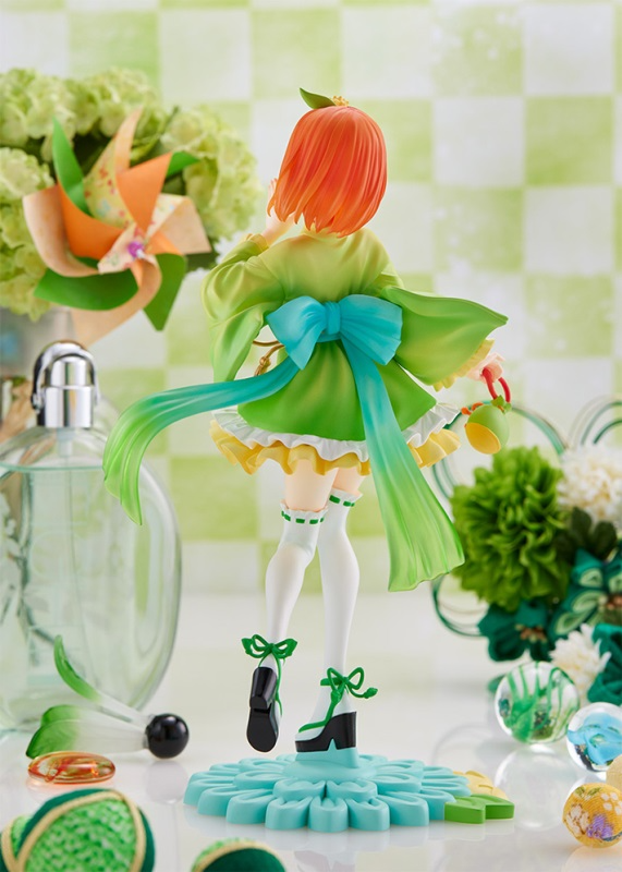 Anime figure of a girl in a green kimono with bright orange hair and a blue bow standing