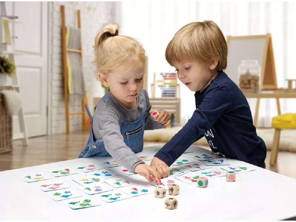 Two children playing a matching card game with dice in a brightly lit playroom