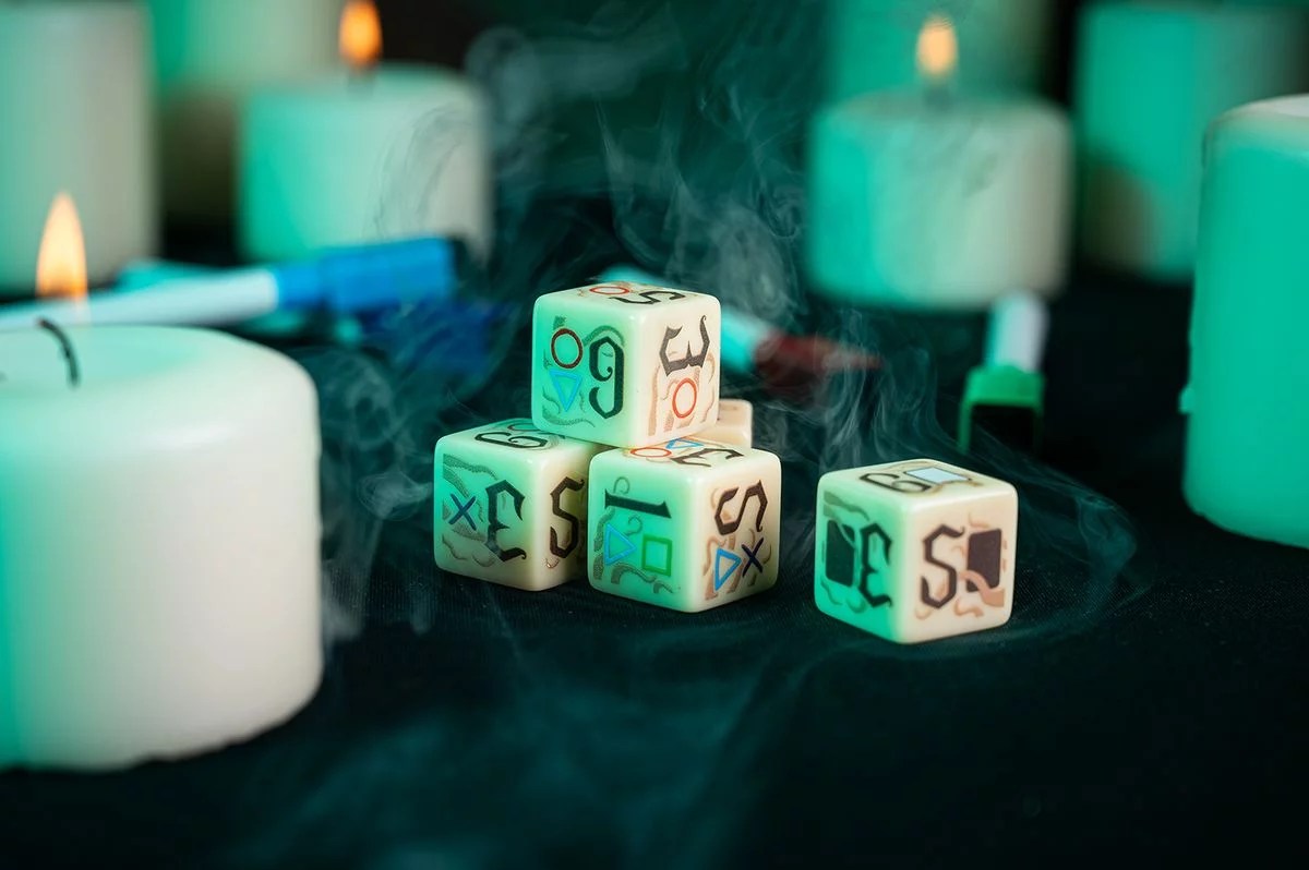 Stack of custom RPG dice with occult symbols, shrouded in smoke and surrounded by glowing white pillar candles
