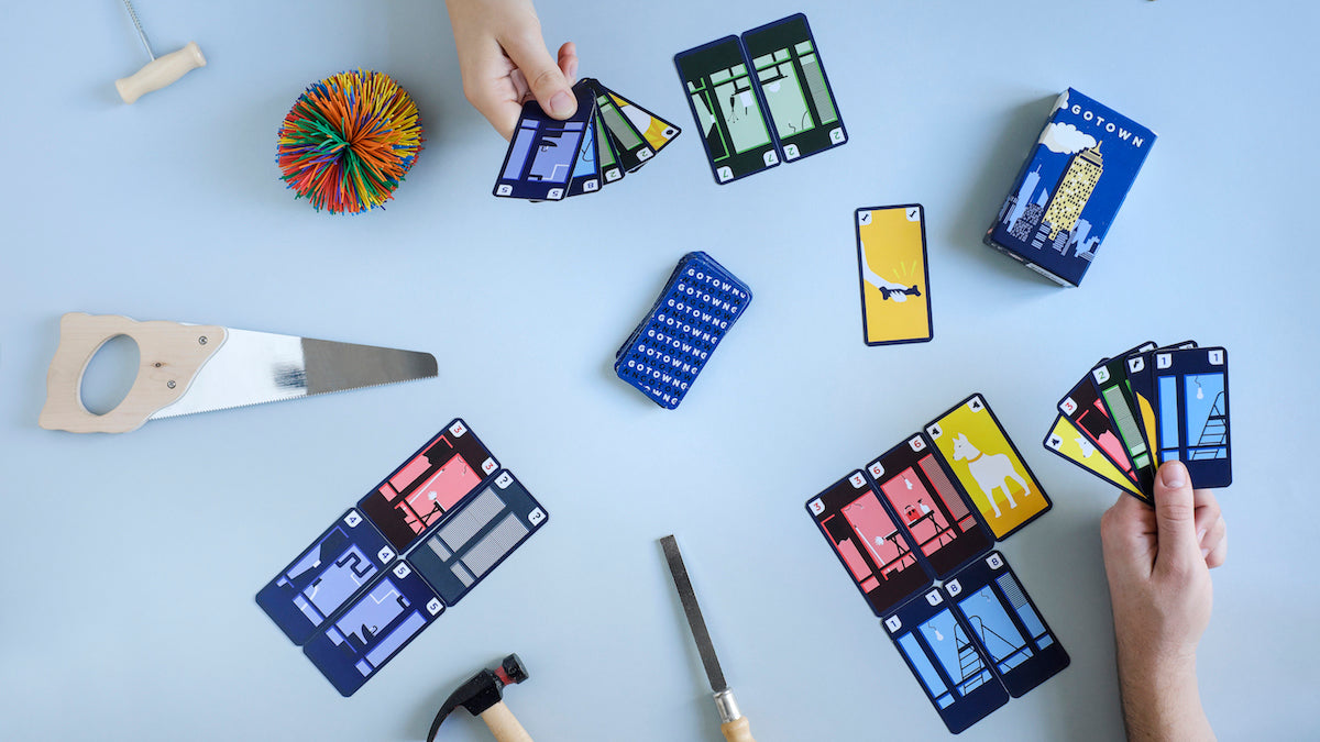 Overhead view of toy saw hammer and file next to cards from the GOTOWN building game