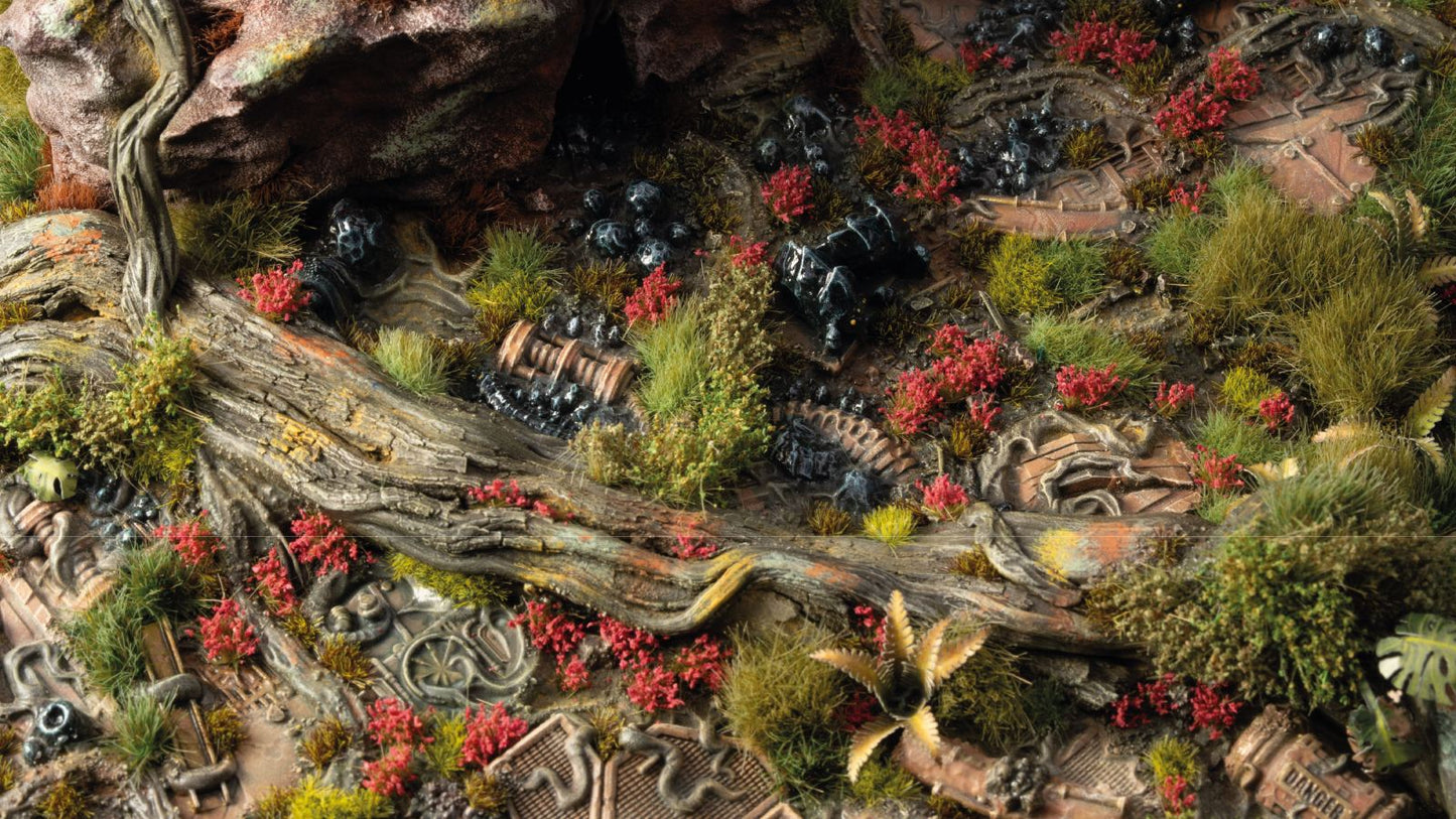 Detailed miniature terrain diorama: lush plants and a log growing over rusted scrap metal and dark, polluted ground