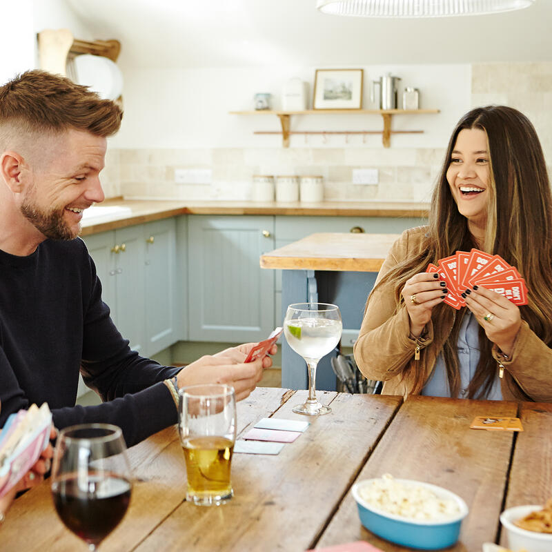 Players playing cards from Don&#39;t Be a Dik Dik on table