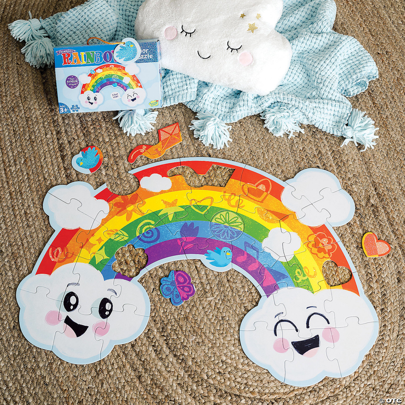 Peaceable Kingdom Shimmery Rainbow Floor Puzzle on a jute rug with cloud pillow and blanket