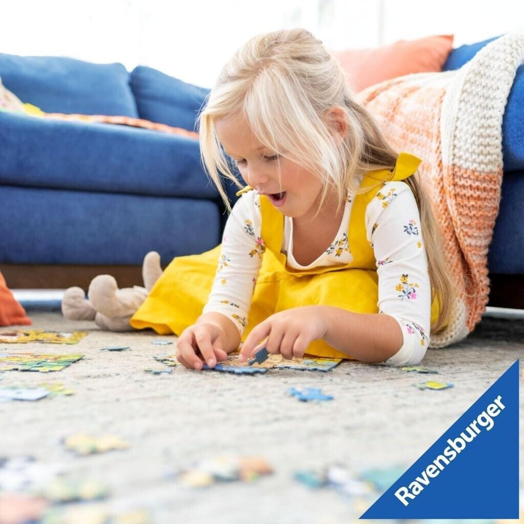 Child concentrates while lying on the floor putting together a jigsaw puzzle