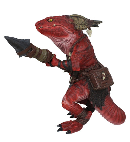 A red, kobold figure with yellow eyes and frills, wearing tribal gear, holding a dark blade forward