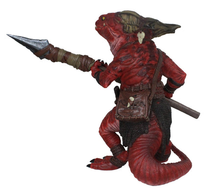 Red, horned reptilian kobold figure wearing a kilt and pouch, holding a spear, facing away from the camera