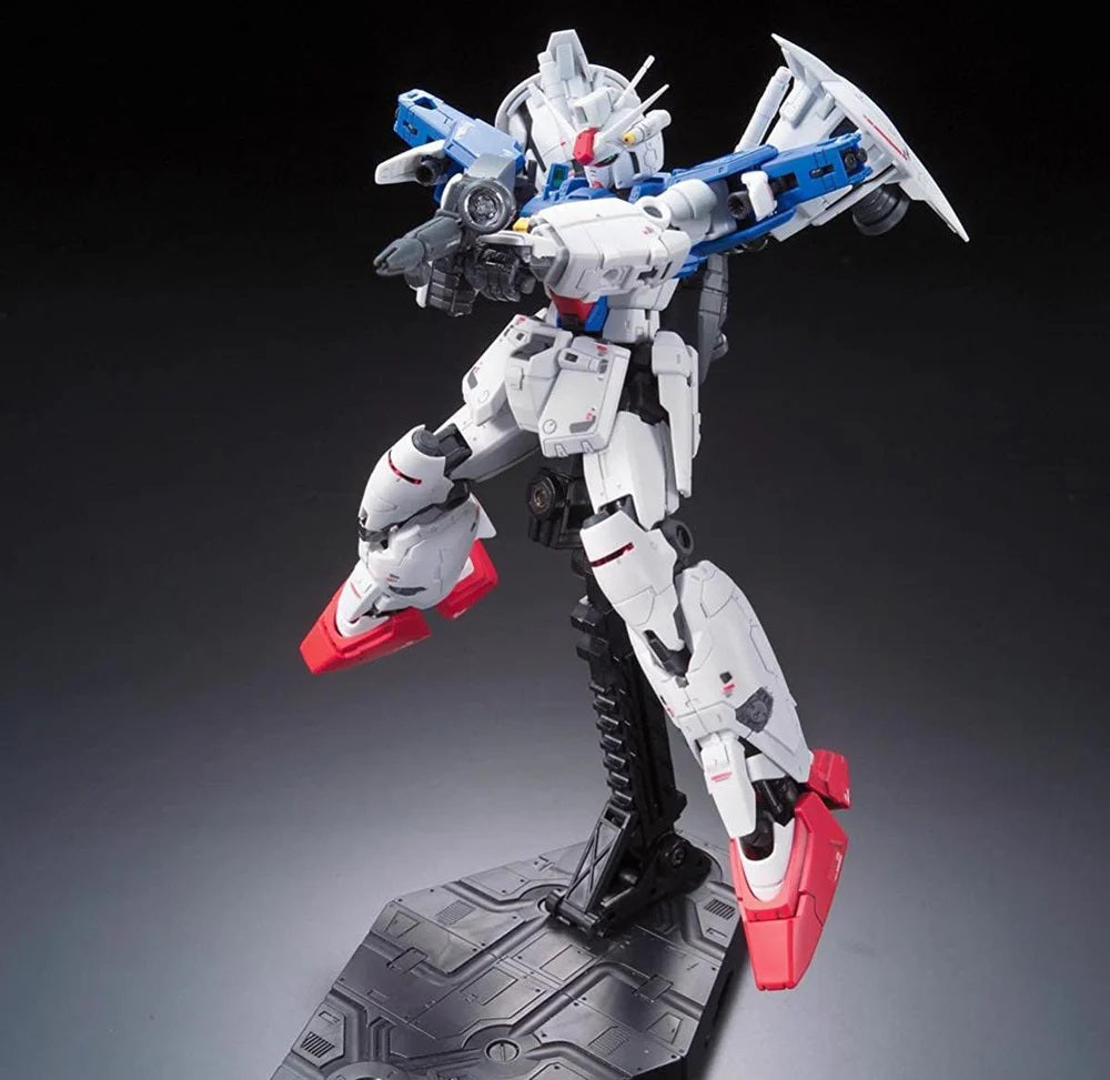 White Gundam mobile suit model, detailed in blue and red, posed dynamically on a stand while aiming a rifle