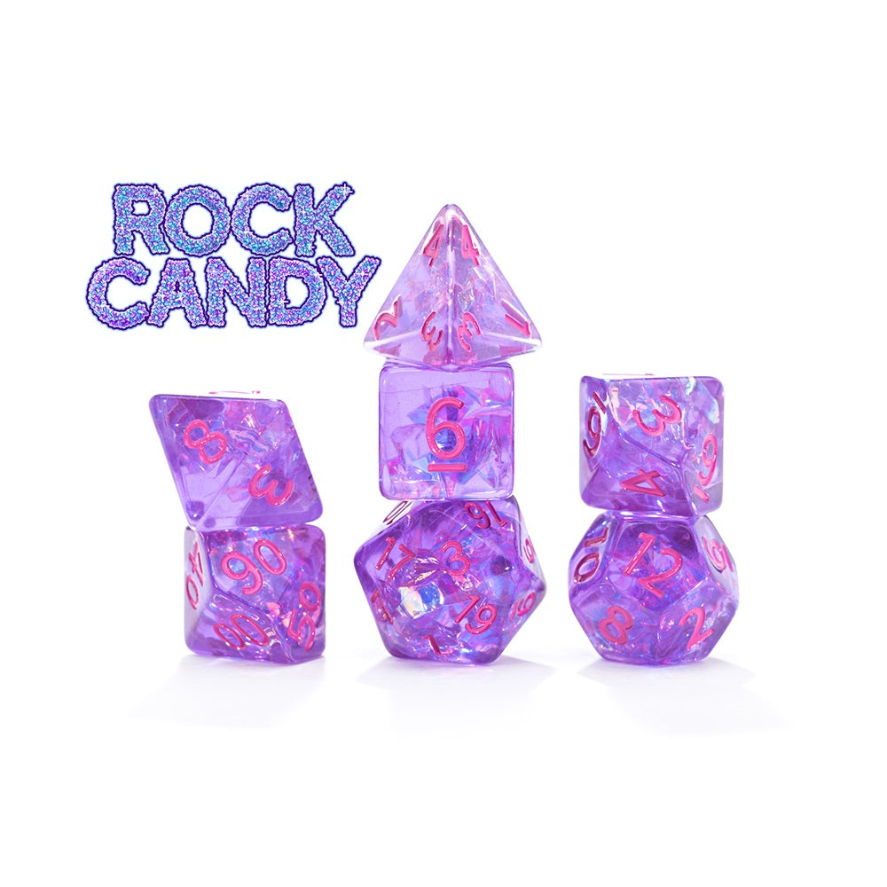 Stacked clear purple polyhedral dice with pink numbers and glitter, on a white background. &quot;ROCK CANDY&quot; text