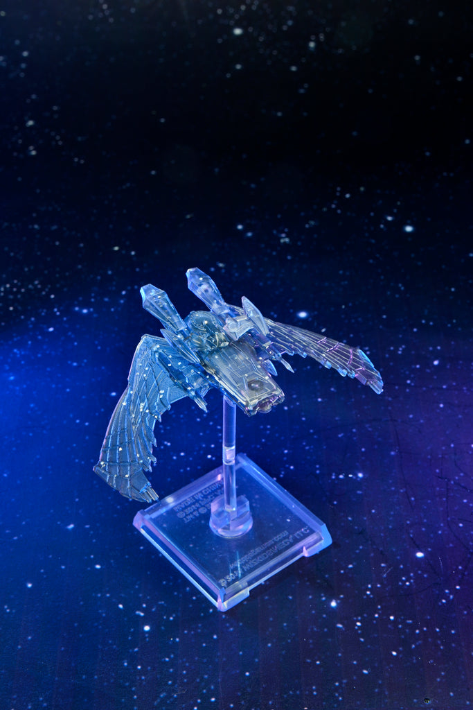 A translucent, winged starship model displayed on a stand, glowing blue against a dark, starry space