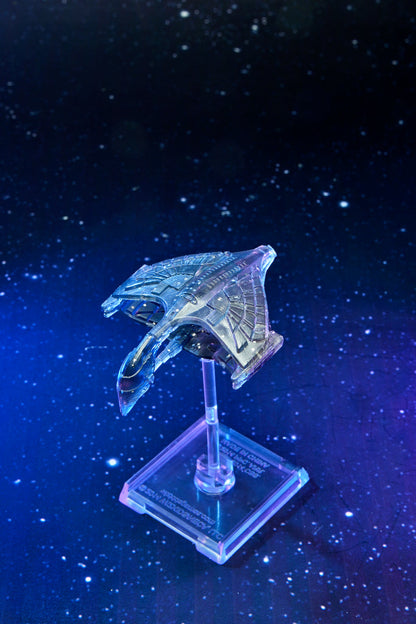 Translucent futuristic spaceship model on a clear stand, illuminated with blue and purple light against a starry background