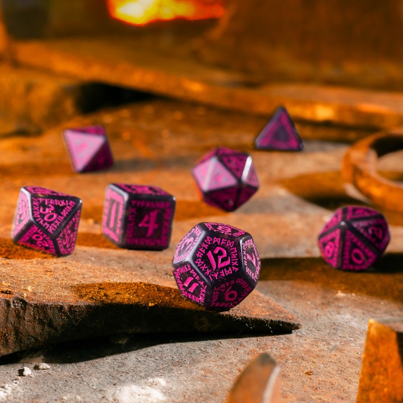 Black and magenta polyhedral dice with runes scattered on a rusty metal surface, with a glowing forge in the background