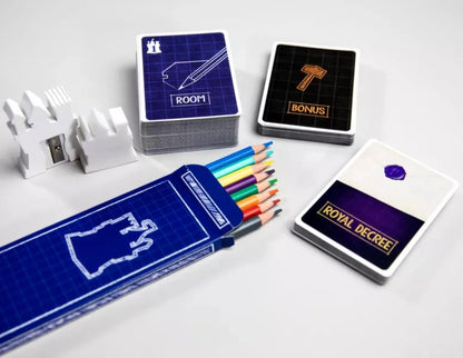 Castle-themed game components: stacks of cards, a white castle-shaped sharpener, and a blueprint pencil case with colored pencils