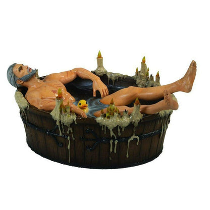 Geralt of Rivia figurine relaxing in a wooden tub with a rubber duck and many dripping candles