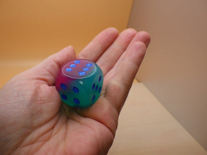 Gel Green Pink and Blue Luminary die showing six blue pips held in a hand   