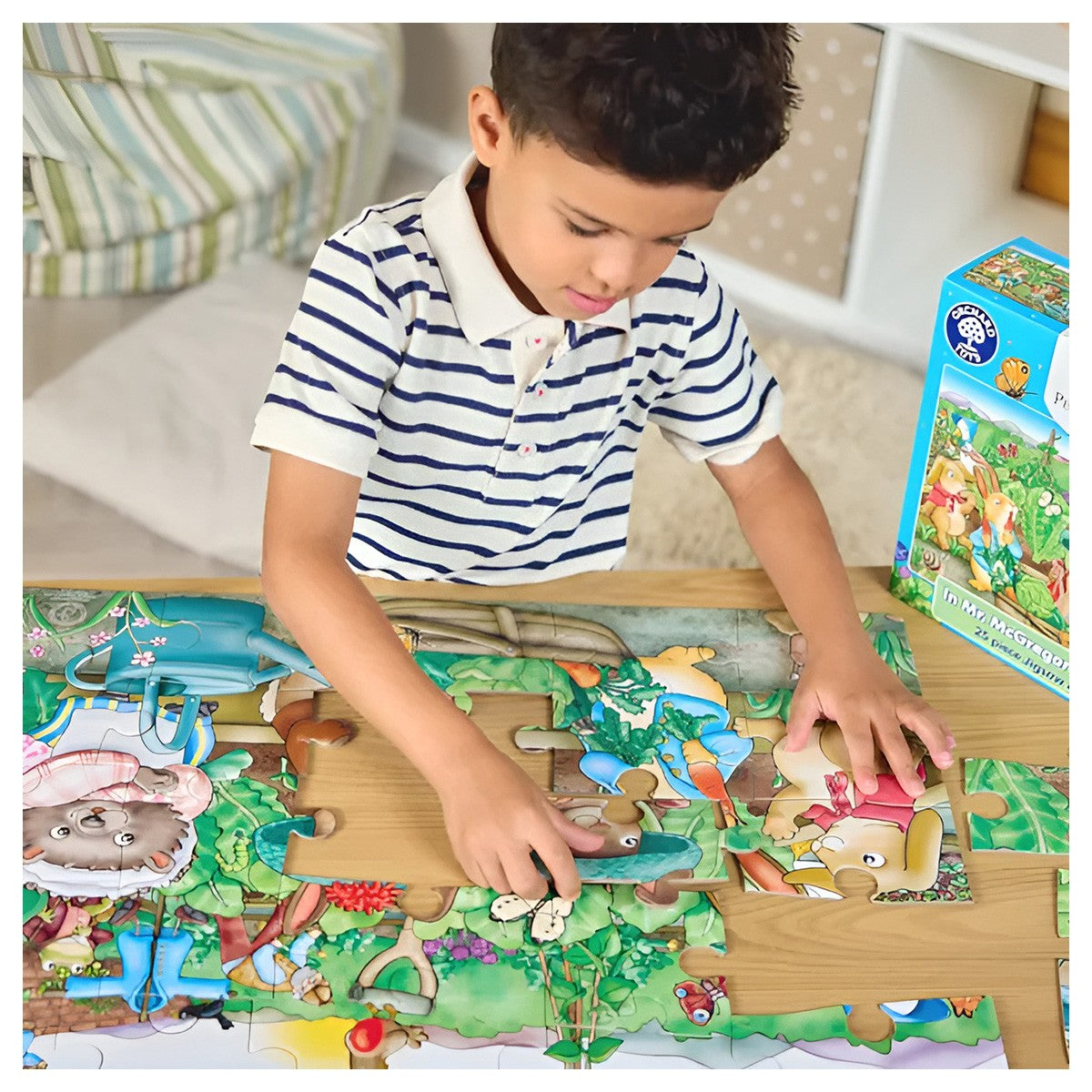 Boy assembling a colorful garden-themed floor puzzle with rabbits and animals