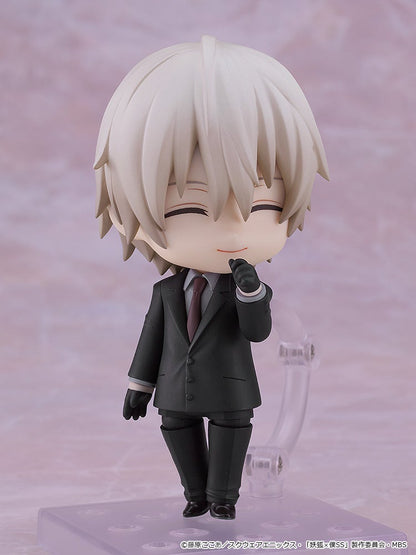 White-haired Nendoroid figure in a dark suit, smiling thoughtfully with a gloved hand on its chin.