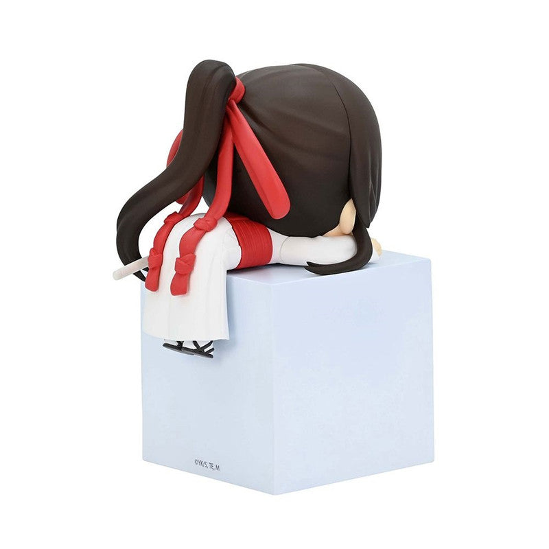 Anime figure of a girl with black hair and red ribbons sitting on a light blue block