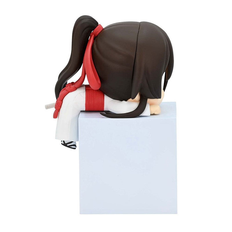 Chibi anime figurine with black hair in a ponytail red ribbon white uniform sitting on a white block