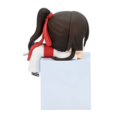 Chibi anime figurine with black hair in a ponytail red ribbon white uniform sitting on a white block