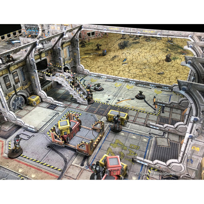 Miniature soldiers battle in a multi-level sci-fi wargame terrain with a desert area beyond.