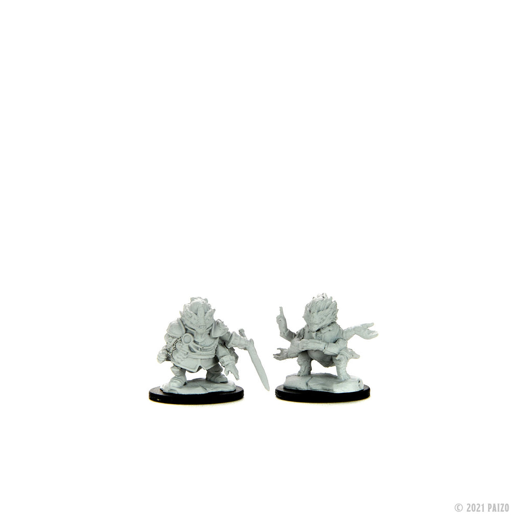 Two unpainted fantasy miniatures: one with a sword, another multi-armed and crouching