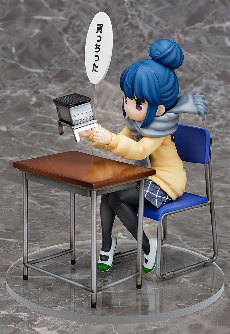 Anime figure of a girl with blue hair in a bun wearing a yellow coat and gray scarf sitting at a desk