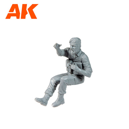 Unpainted gray plastic model of a bearded soldier in a beret -  seated -  shouting -  holding binoculars & pointing