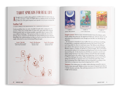 Open book displaying a "Tarot Spreads for Real Life" article, with a person falling from a cliff and three tarot cards