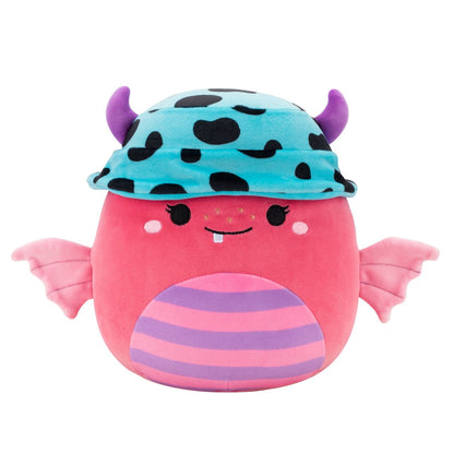 The bright pink Squishmallow monster plush features small pink wings and purple belly stripes while wearing a blue and black spotted beanie with purple horns
