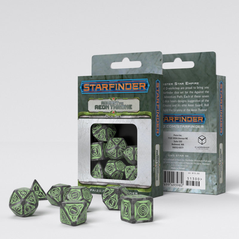 Two boxes for the Starfinder Against The Aeon Throne Dice Set stand behind a scattering of gray and green gaming dice