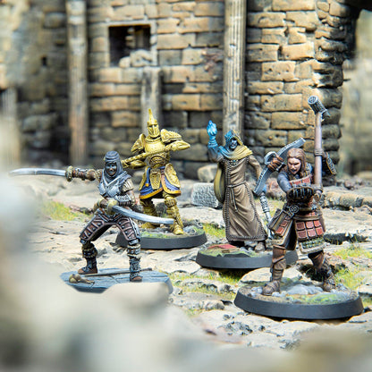 Four fantasy miniatures: a dual-wielding fighter, golden warrior, wizard with blue magic, and a warrior, posed amidst ruins