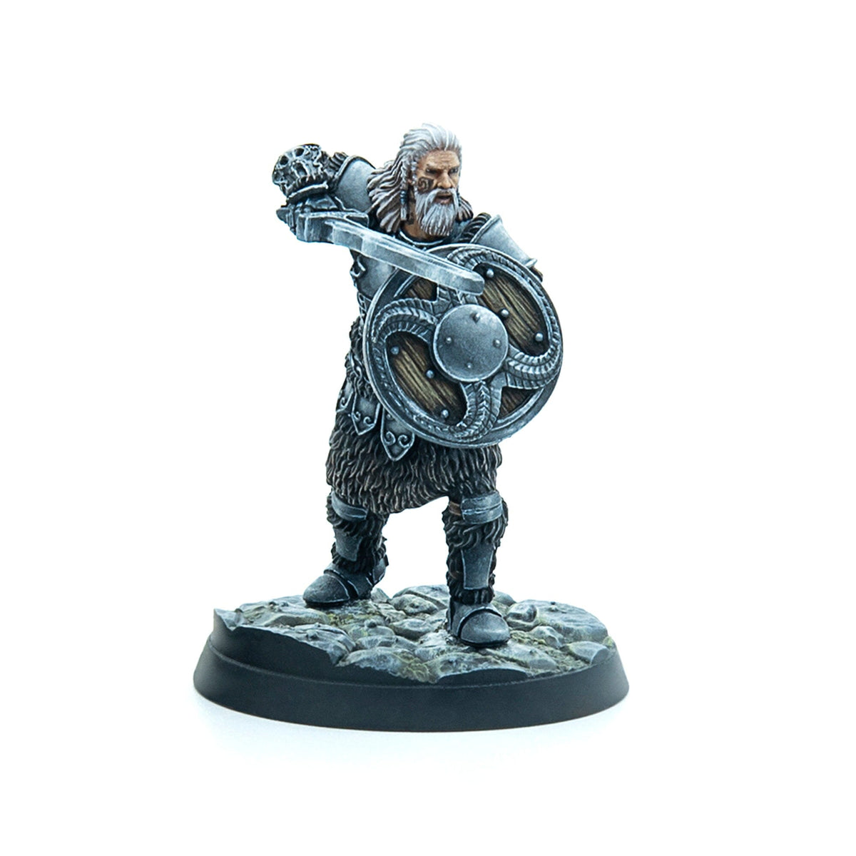 A miniature of a bearded warrior in fur and metal armor, holding a shield and raising a large weapon