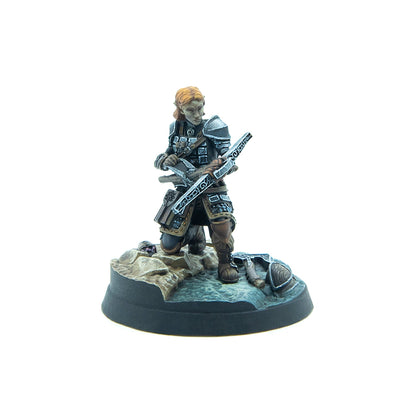 Painted miniature of an elf warrior with reddish hair and dark armor, kneeling and holding a crossbow
