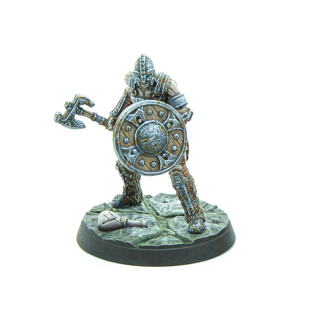 A detailed miniature figure of an armored warrior holding an axe and a round shield on a textured base