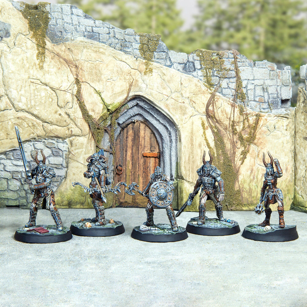 Five fantasy horned warriors stand armored with various weapons before a ruined stone wall with a wooden door