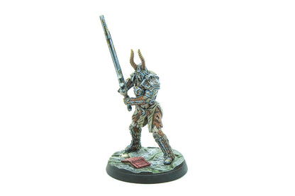 A painted miniature of a horned warrior in ornate armor holding a large sword, standing ready on a textured base