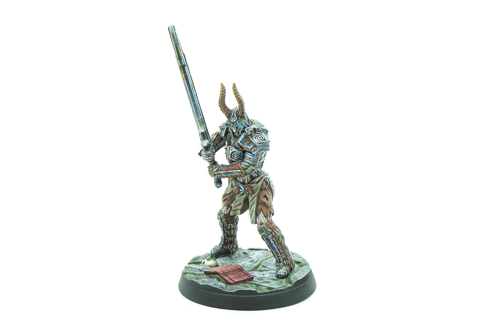 A painted miniature of a horned warrior in ornate armor holding a large sword, standing ready on a textured base