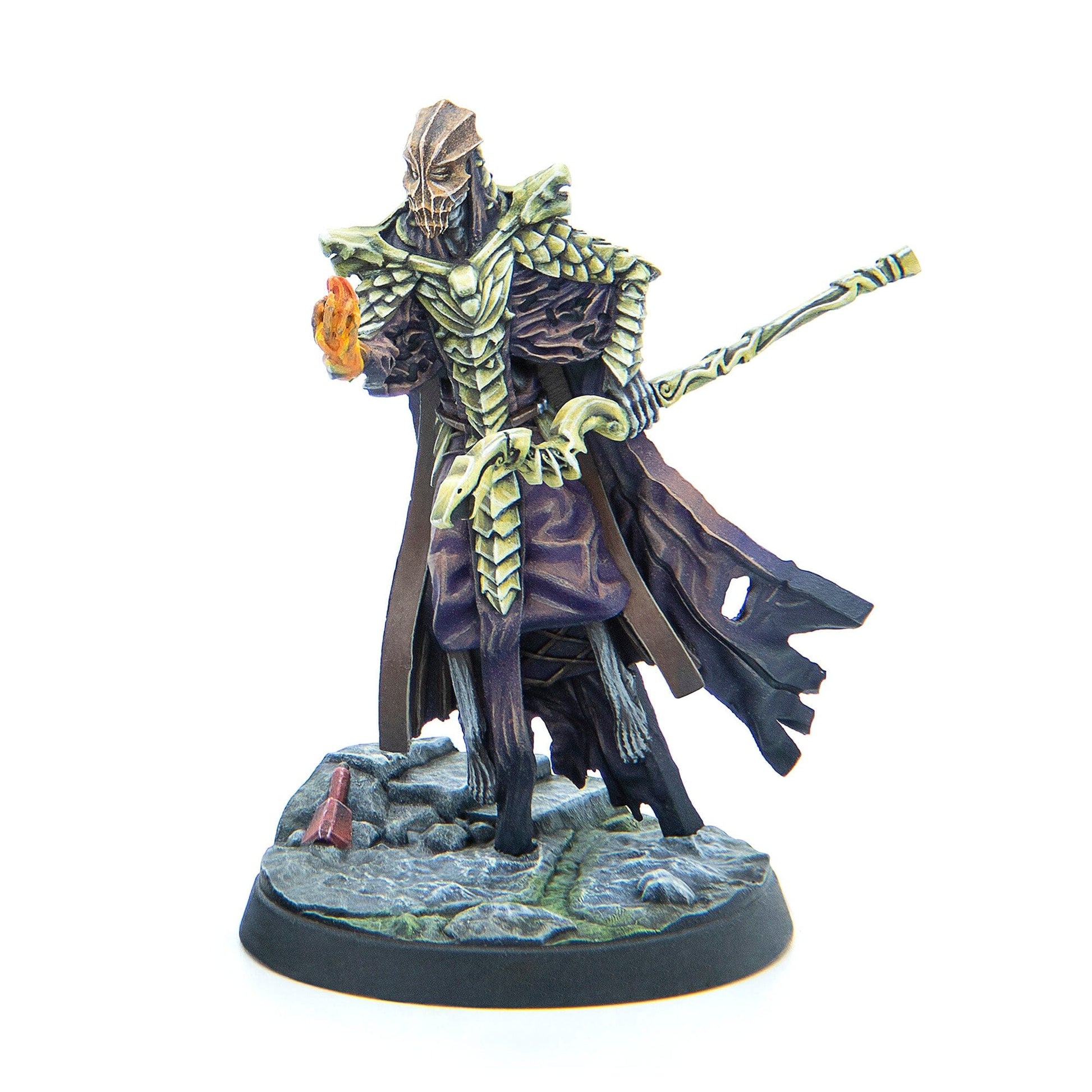 Painted miniature of a masked, armored figure holding a glowing flame and an ornate staff
